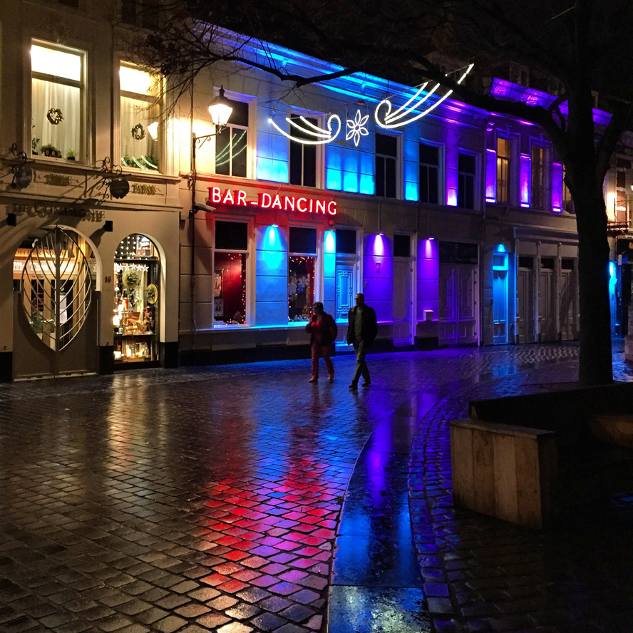 Twee mensen lopen door natte, reflecterende straten in de nacht, binnenstad Breda