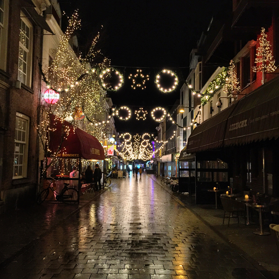 Straatfotografie: beeld van natte, reflecterende straat in de nacht in de binnenstad van Breda
