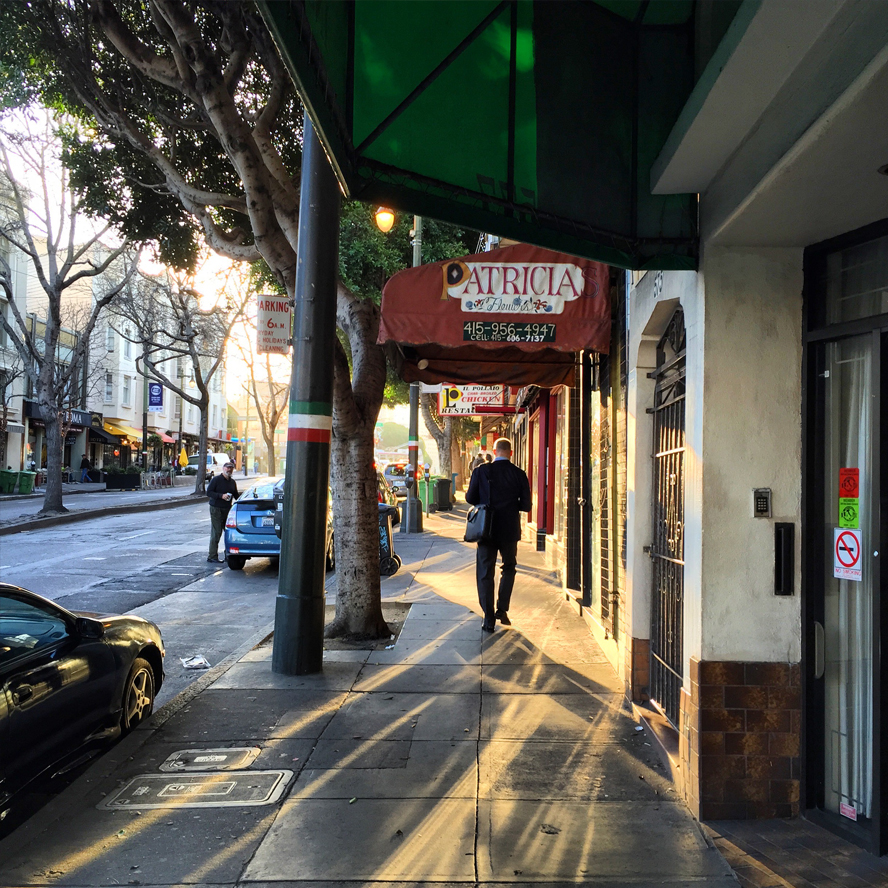 Straatfoto in tegenlicht, man loopt in Little Italy, San Francisco