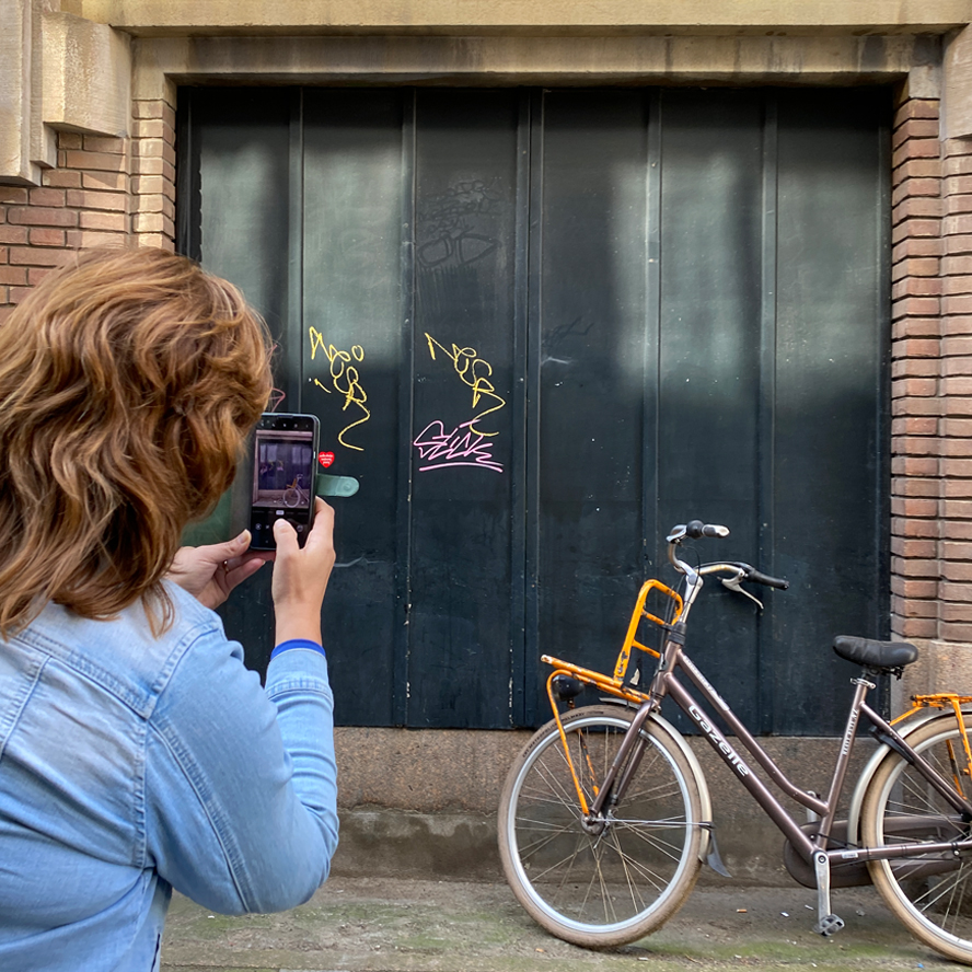 Oude deur en fiets, op de foto gezet door een dame met een smartphone