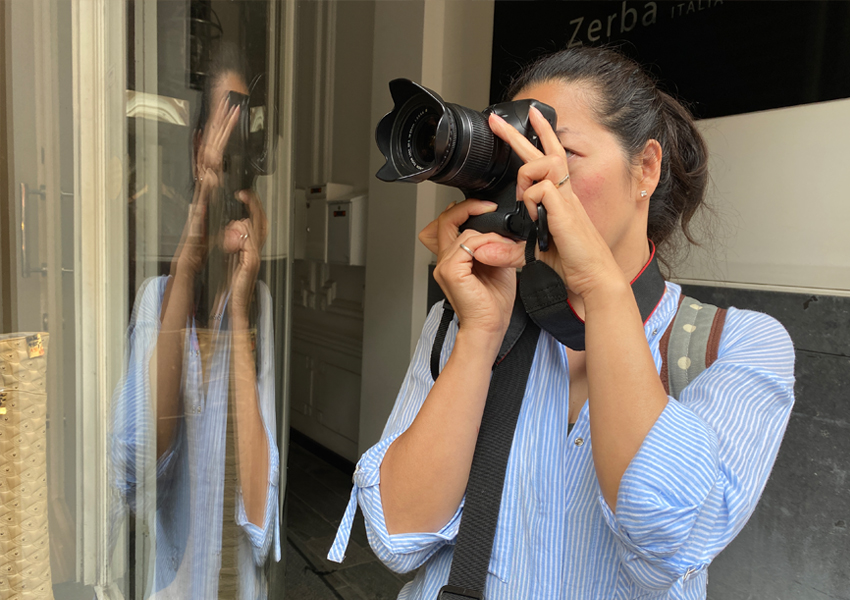 Fotograaf aan het werk, weerspiegeling in etalageruit in Den Haag