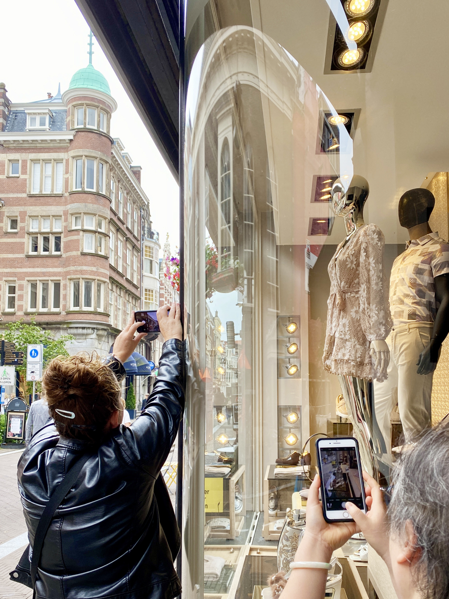 Fotografen maken foto van weerspiegeling in etalageruit in Den Haag