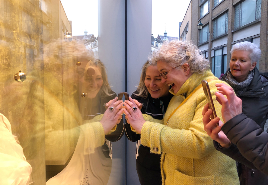 Eyespiration photo walk Breda, fotograaf Melanie Rijkers legt spiegeling in ruit uit aan enthousiaste deelnemer