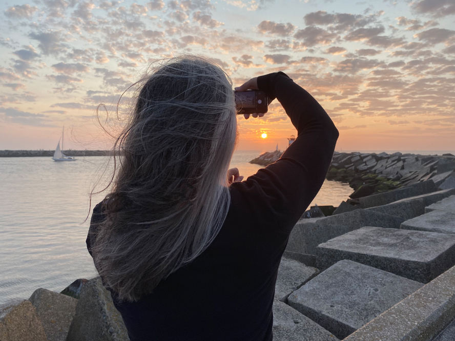 Fotograaf Melanie E. Rijkers maakt foto van de zonsondergang aan zee in Scheveningen Haven