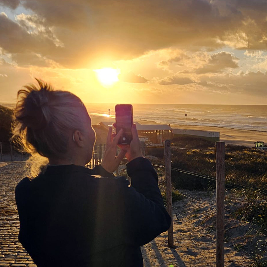 Melanie E. Rijkers fotografeert zonsondergang vanaf de boulevard op Kijkduin
